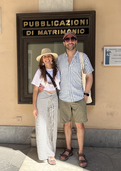 Camilo y Eli frente al tablero de las Pubblicazioni di Matrimonio en Italia