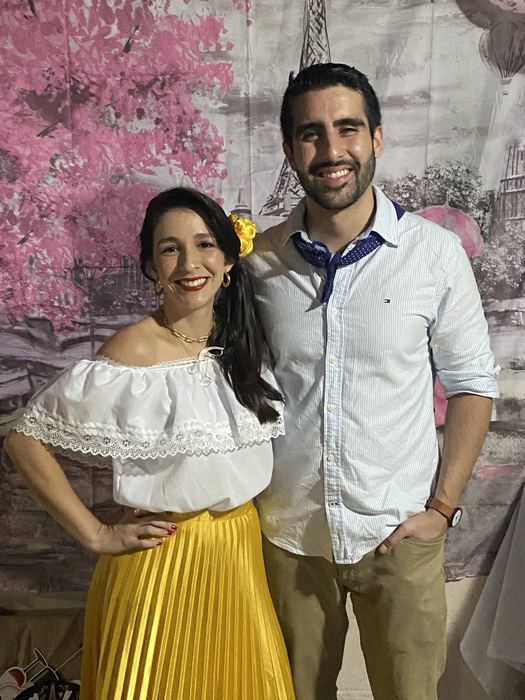 Camilo y Eli bajo un árbol de flores rosadas