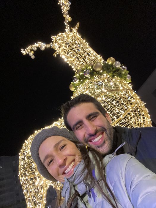 Selfie de noche frente a un reno de luces navideñas