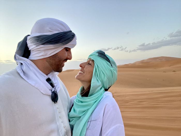 Camilo y Eli con turbantes en el desierto, mirándose