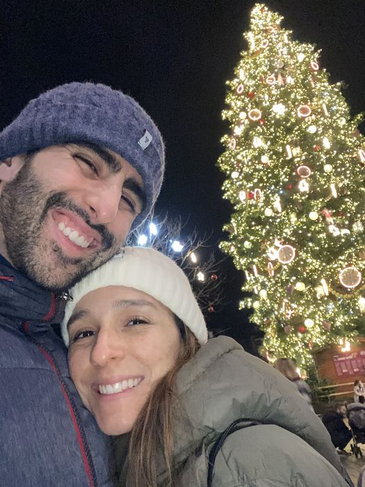 Abrigados junto a un árbol de Navidad iluminado