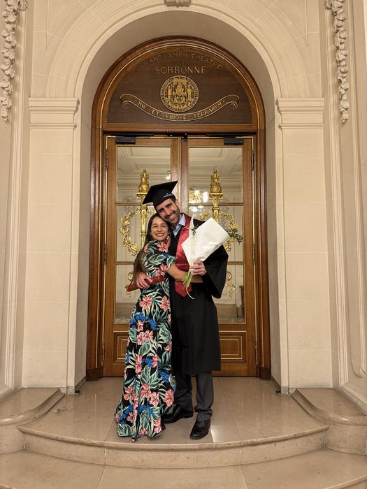 Camilo, graduado de la Sorbona, abraza a Eli con un ramo de flores
